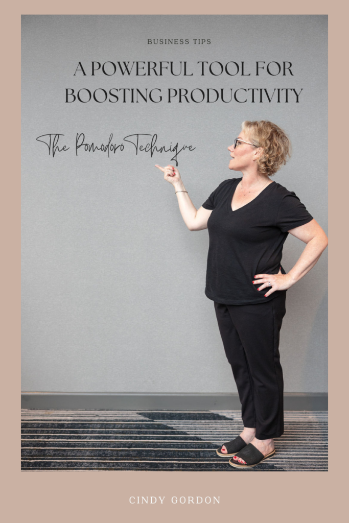 Blog post graphic that features cindy gordon dressed in all black pointing to a grey wall that says a powerful tool for boosting productivity